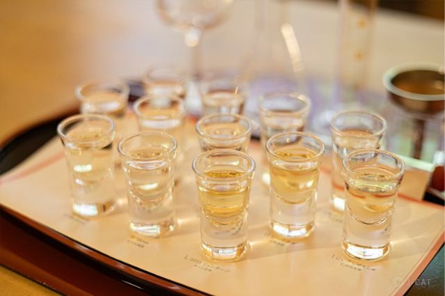 Small tasting glasses filled with different varieties of Japanese sake arranged on a tray during a private tasting session in Kyoto.