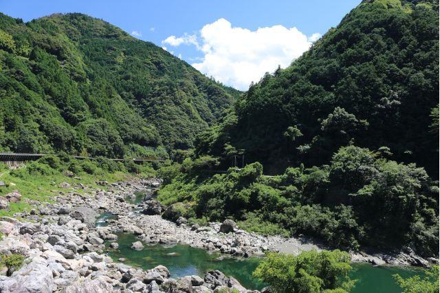 Summer river landscape in Akigawa Valley, Akiruno, Tokyo surrounded by forested mountains