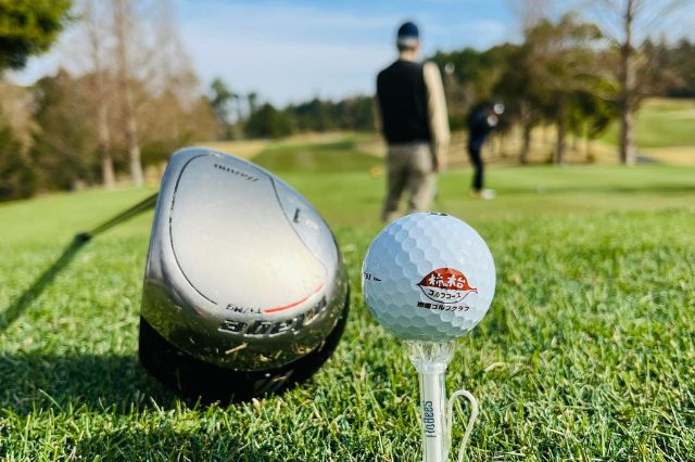 Close-up of golf ball on tee with driver on grass at a Japanese golf course