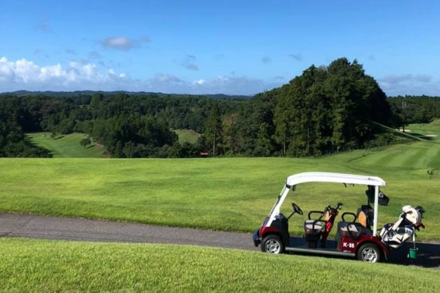 Golf cart parked beside a fairway on a scenic Japanese golf course
