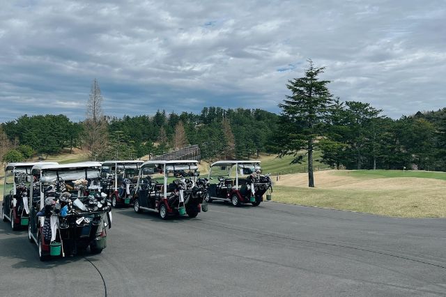 Multiple golf carts lined up at a Japanese golf course ready for players