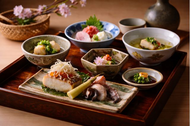 Traditional kaiseki-style meal with seasonal Japanese dishes arranged on lacquer tray in Tokyo